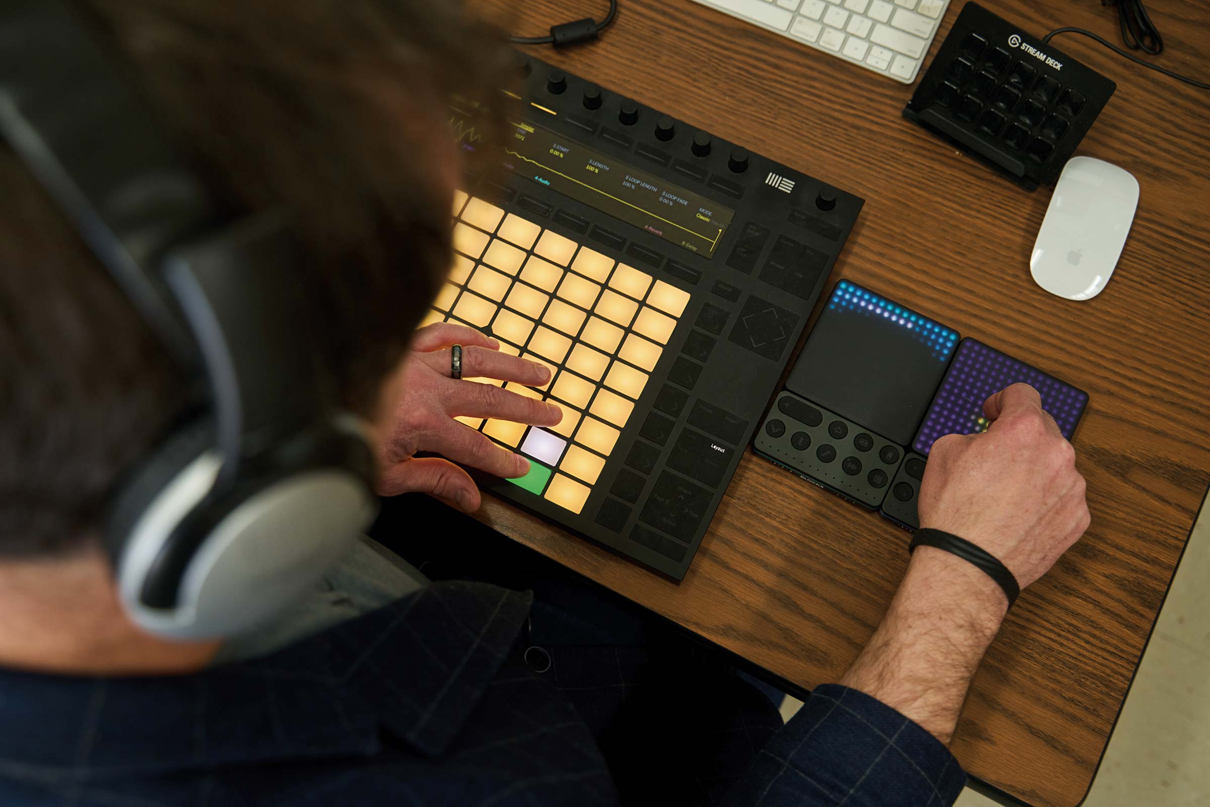 Jeremy Morris wears headphones and presses buttons on a sound board