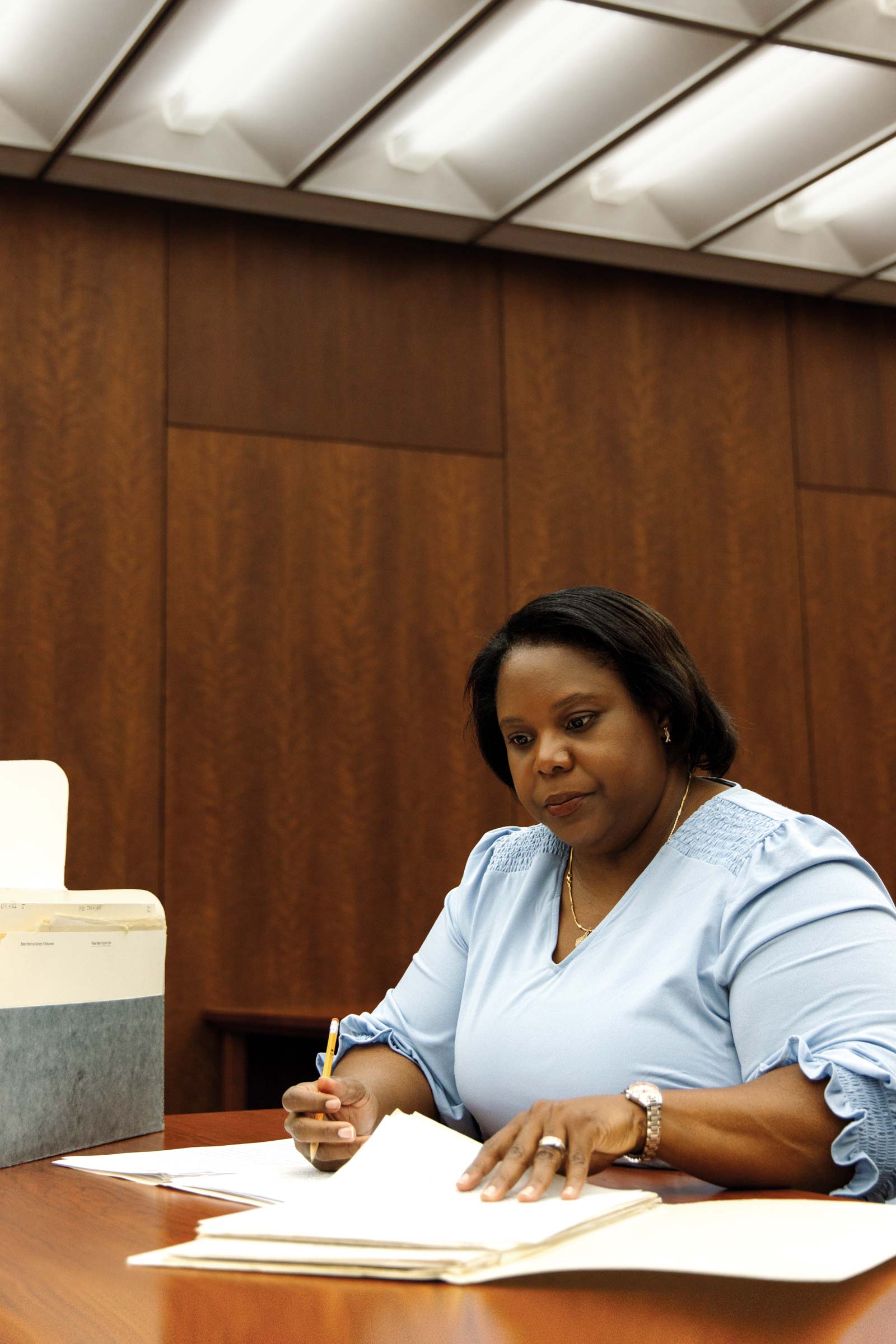 Christy Clark-Pujara sits at a table looking at documents.