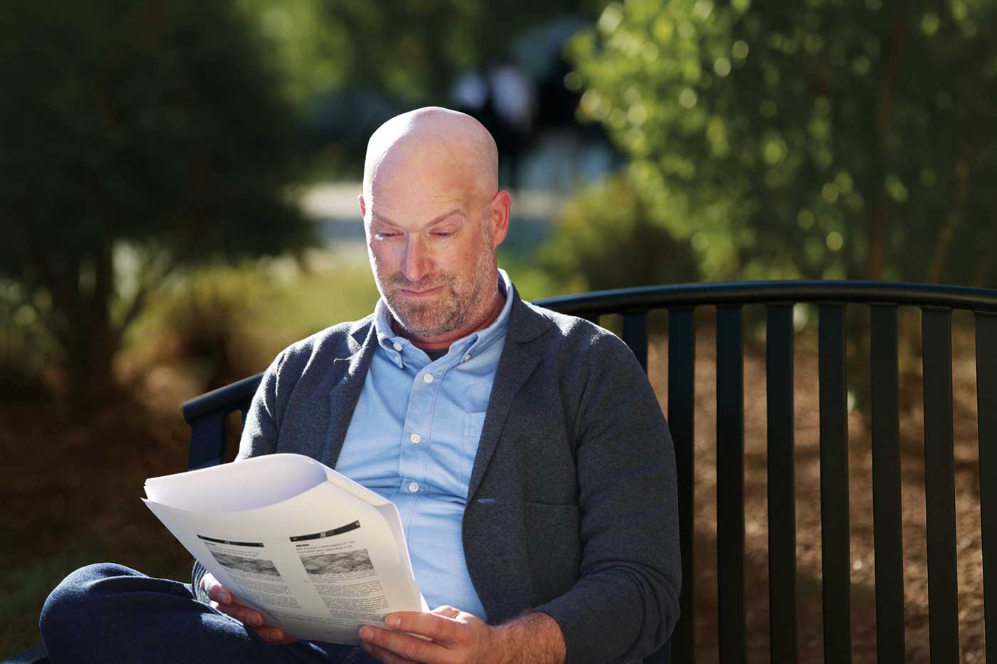 Mark Copelovitch sits on a bench reading documents